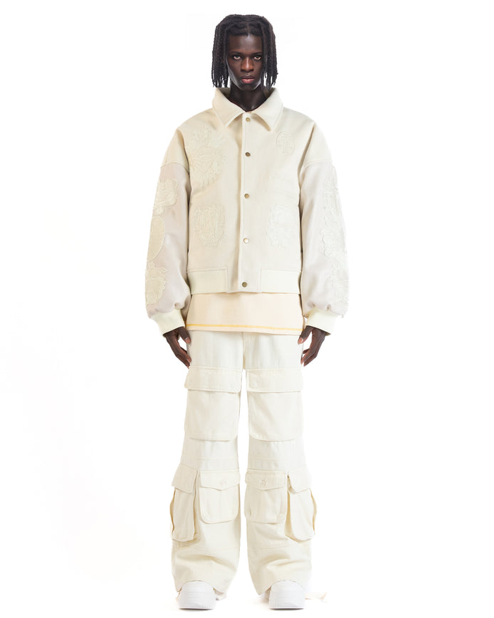 Untitled Artworks “Angel of Peace” varsity jacket in white with peace symbol embroidery and patches, oversized fit.