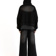 Back view of the Untitled Artworks Consumed Hoodie in black, showcasing its oversized fit, kangaroo pocket, and unique stone wash effect.