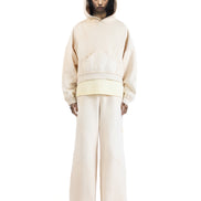 Front view of the Untitled Artworks Consumed Hoodie in cream, showcasing its oversized fit, kangaroo pocket, and unique stone wash effect.