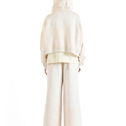 Back view of the Untitled Artworks Consumed Hoodie in cream, showcasing its oversized fit, kangaroo pocket, and unique stone wash effect.