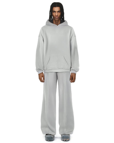 Untitled Artworks Essential Hoodie in Light Grey – oversized cotton-blend hoodie with raw-edge accents and kangaroo pocket. on model 
