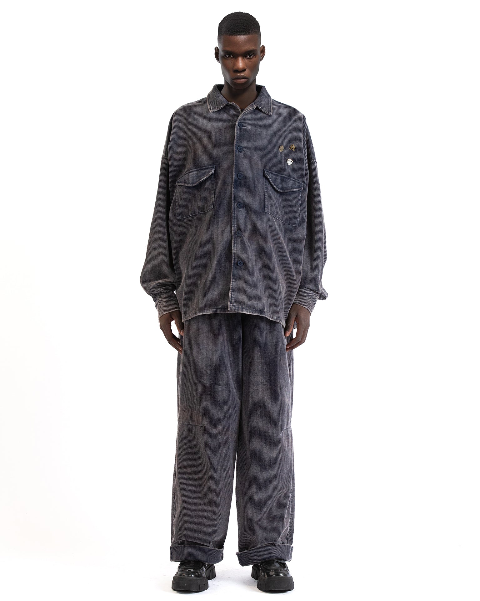 Front view of the blue corduroy shirt showing its button-front and boxy fit