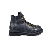 Close-up side view of the Untitled Artworks x Fracap Destroyer Boot in black, showcasing its spray-effect finish, oversized fold-over tongue, and antique brass eyelets.