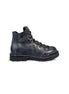 Close-up side view of the Untitled Artworks x Fracap Destroyer Boot in black, showcasing its spray-effect finish, oversized fold-over tongue, and antique brass eyelets.