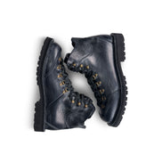 Close-up top down view of the Untitled Artworks x Fracap Destroyer Boot in black, showcasing its spray-effect finish, oversized fold-over tongue, and antique brass eyelets.