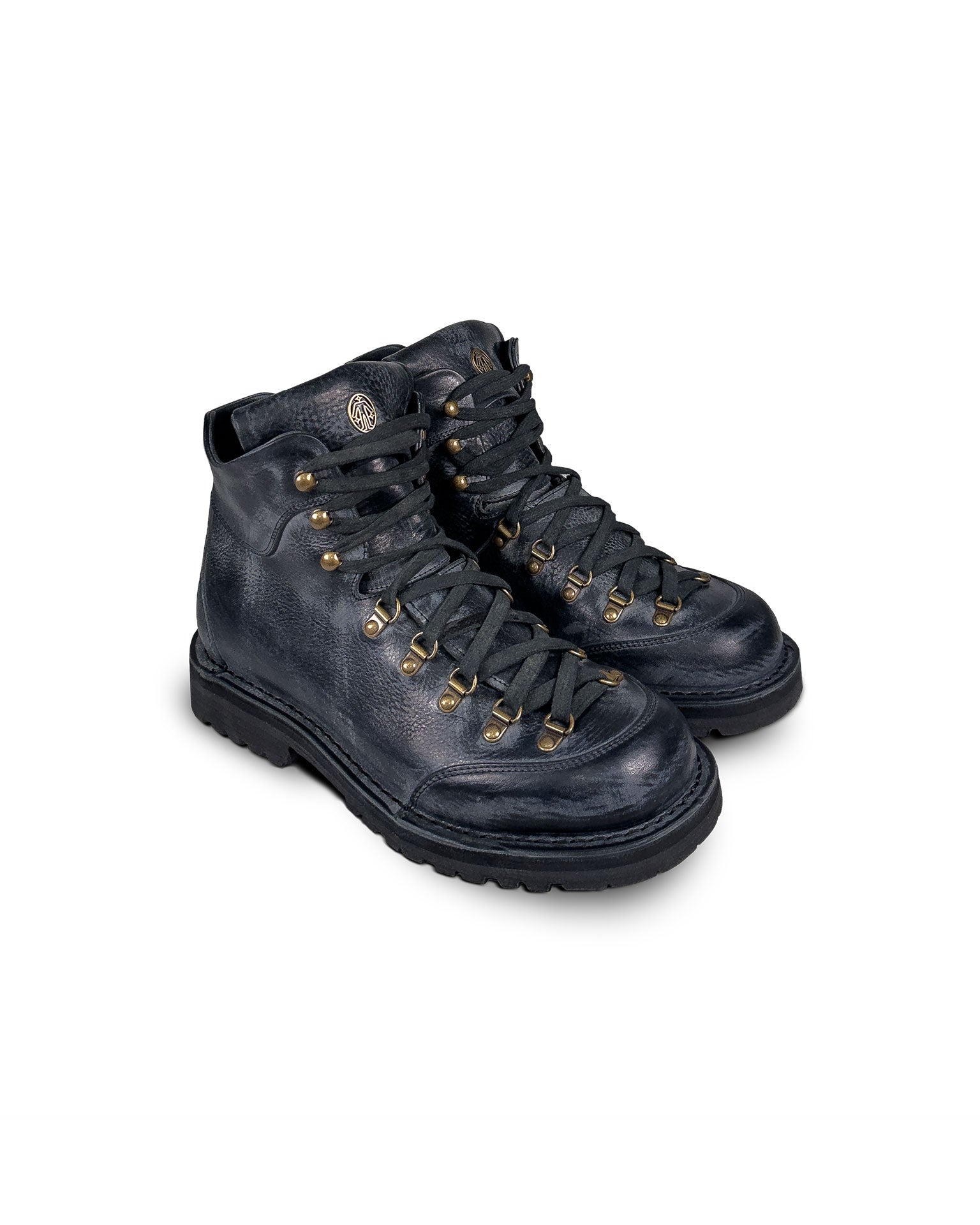 Close-up 3/4 view of the Untitled Artworks x Fracap Destroyer Boot in black, showcasing its spray-effect finish, oversized fold-over tongue, and antique brass eyelets.