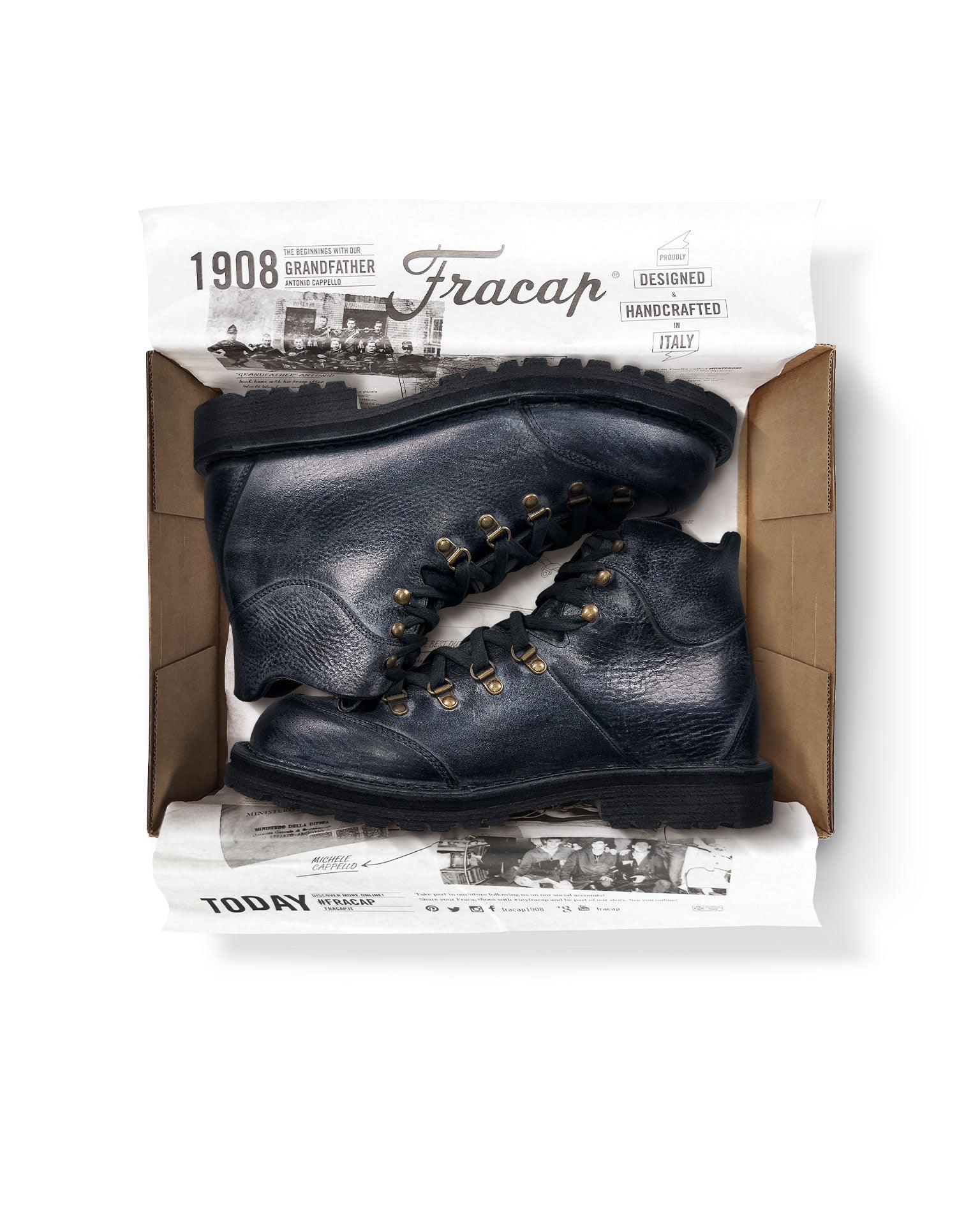 Close-up in box view of the Untitled Artworks x Fracap Destroyer Boot in black, showcasing its spray-effect finish, oversized fold-over tongue, and antique brass eyelets.